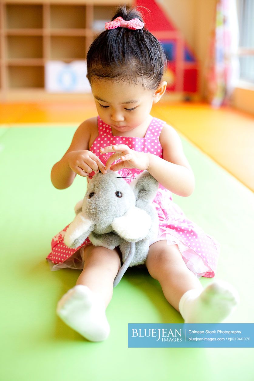 Chinese girl playing with stuffed animal