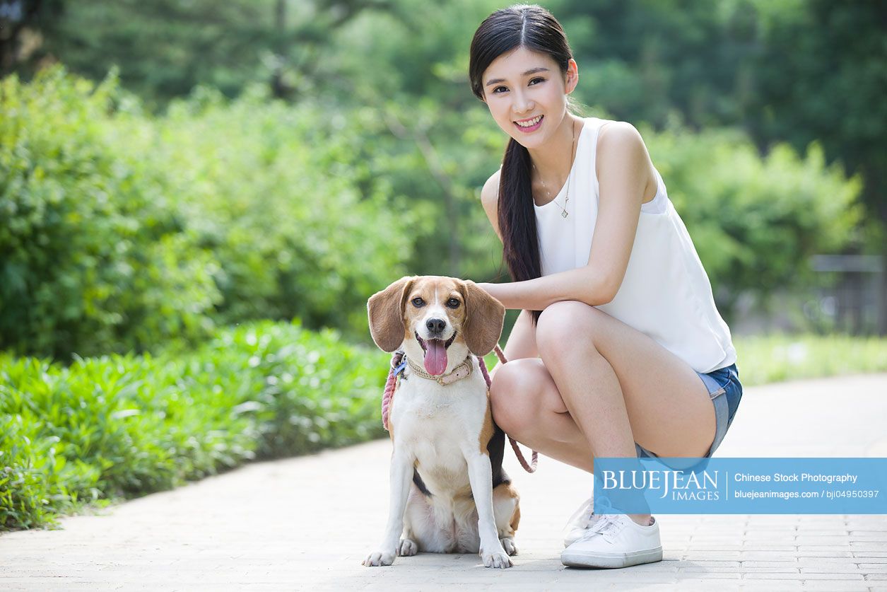 Young Chinese woman playing with a cute dog
