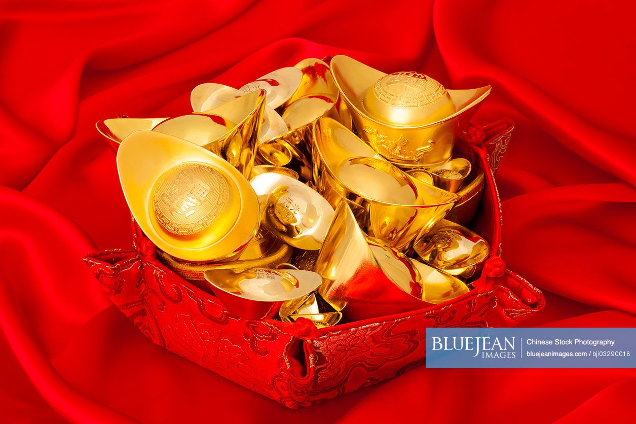 Chinese traditional currency gold yuanbao ingots in red background