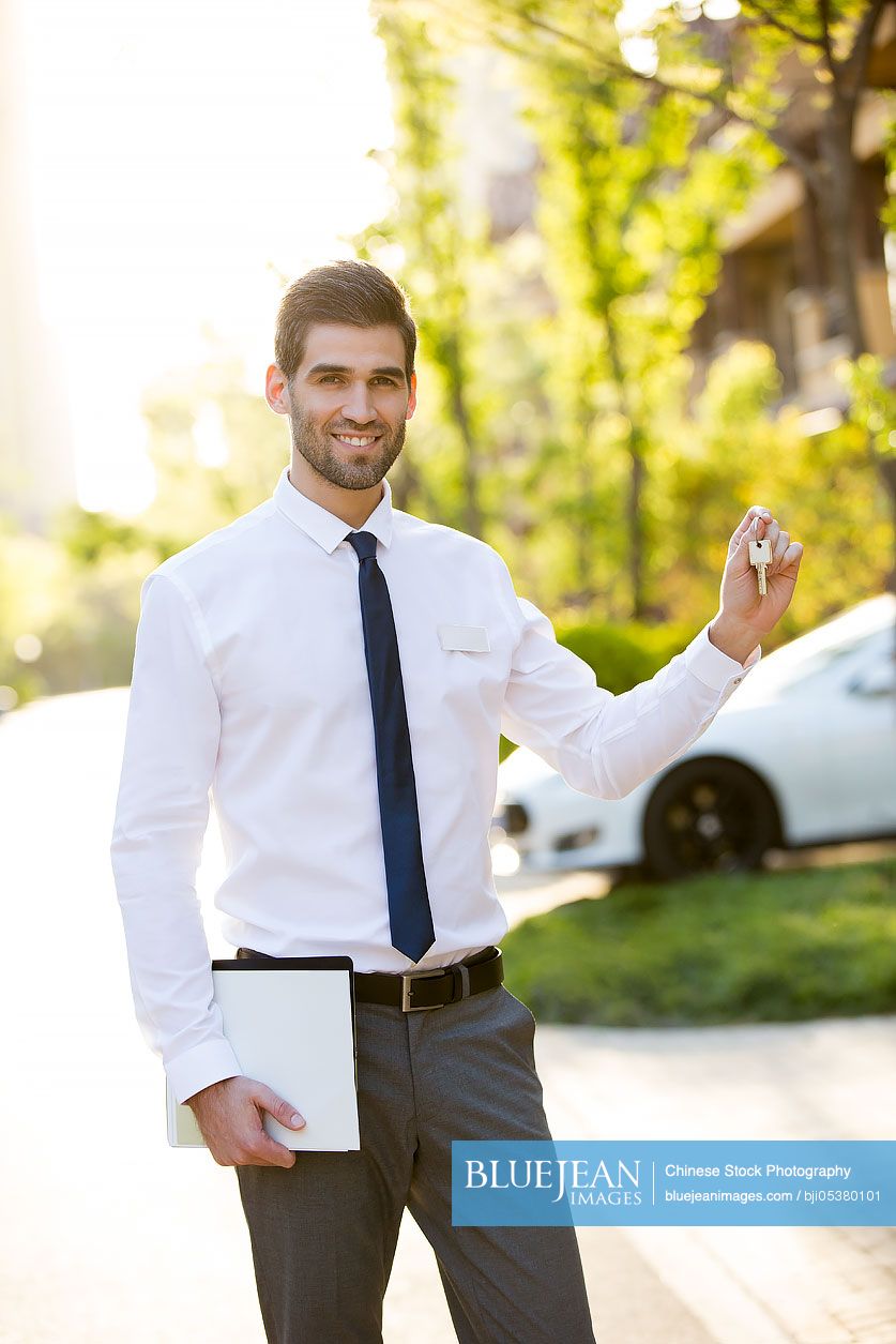 Confident businessman holding keys