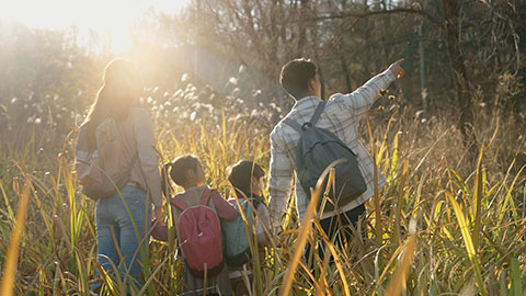 Happy young Chinese family hiking outdoors