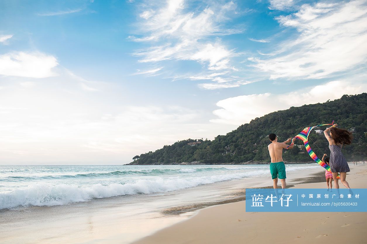 快乐的年轻家庭在沙滩放风筝