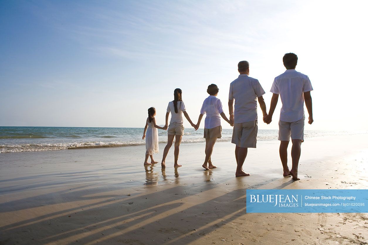 Portrait of a Chinese family walking along the beach