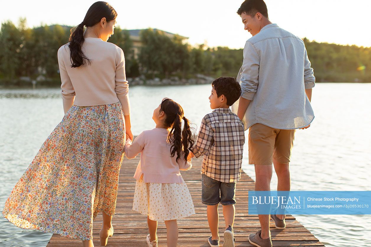 Happy young Chinese family relaxing in park