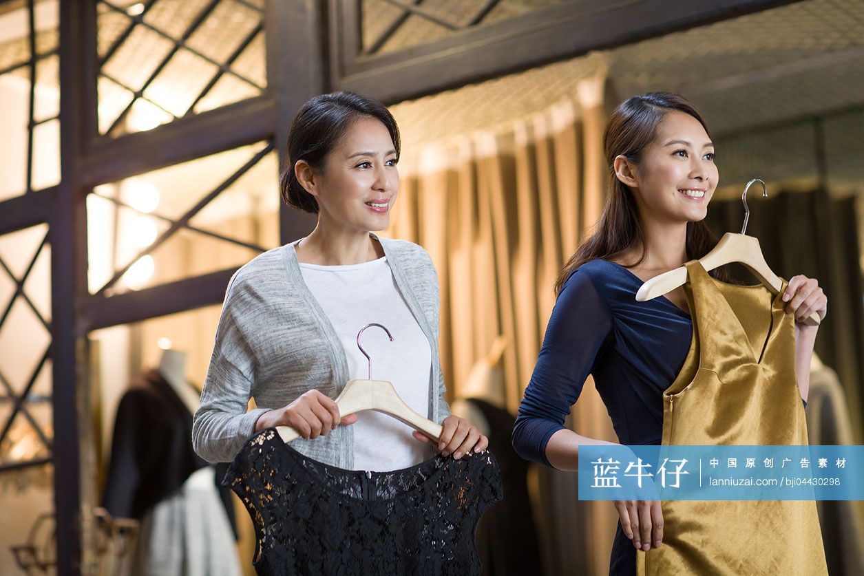 服装店主帮助顾客挑选衣服