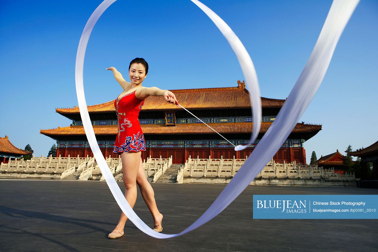 Young Chinese Woman Ribbon Dancing In Front Of A Temple