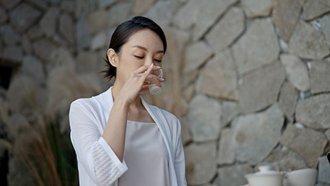 Elegant young Chinese woman drinking tea in tea room,4K