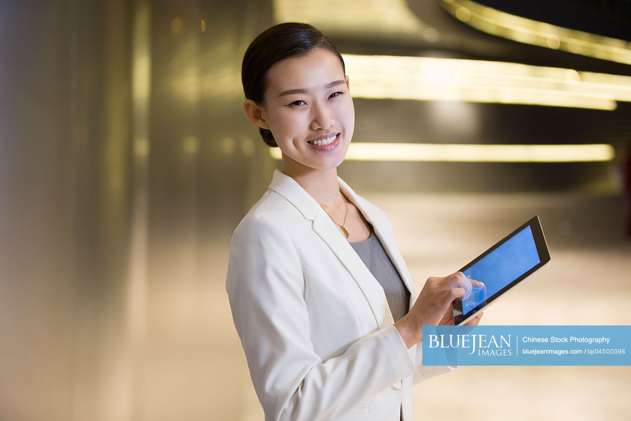 Chinese businesswoman using digital tablet outdoors