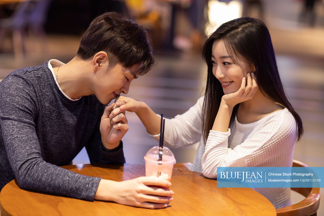 Happy young Chinese couple dating in shopping mall