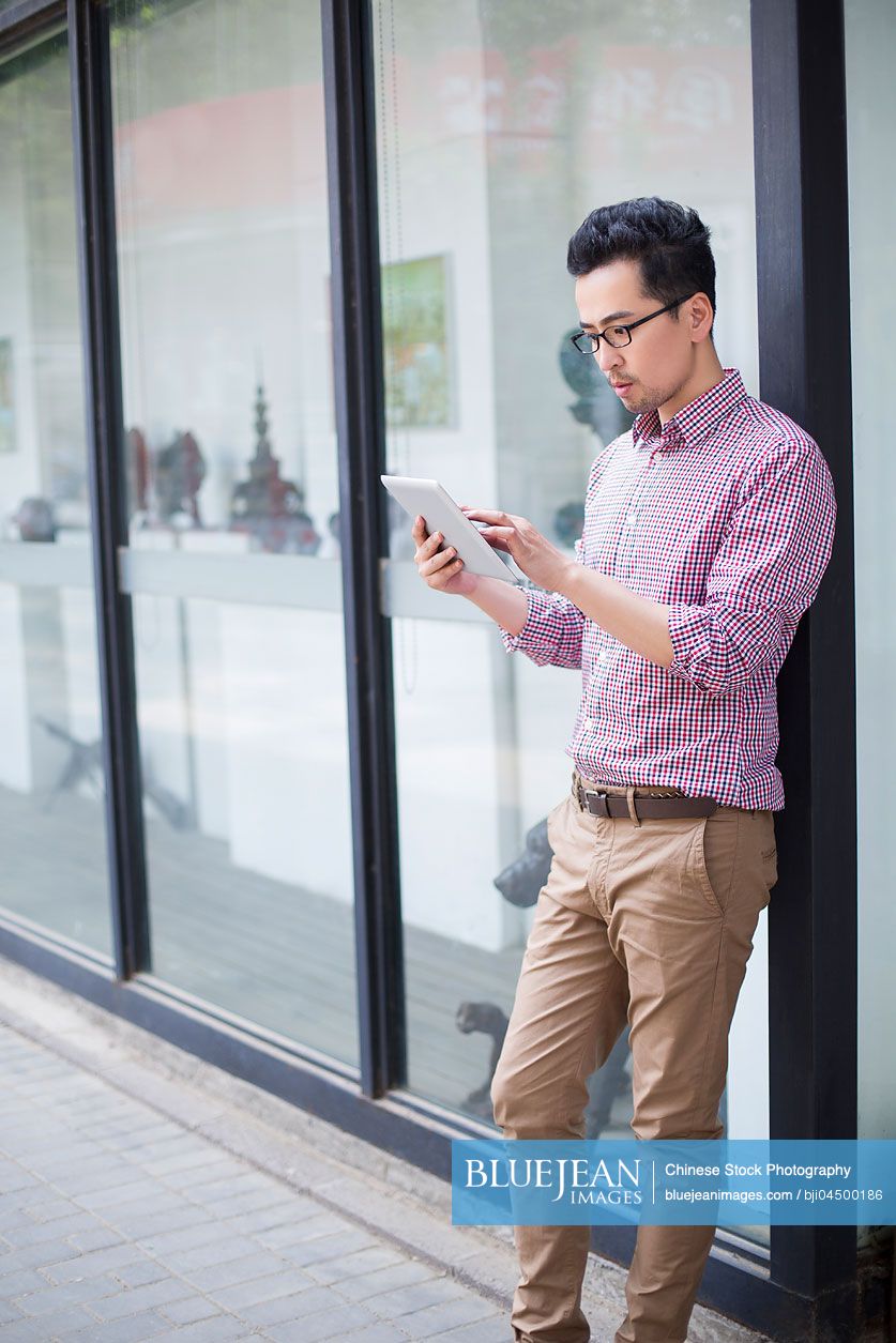 Chinese man using digital tablet