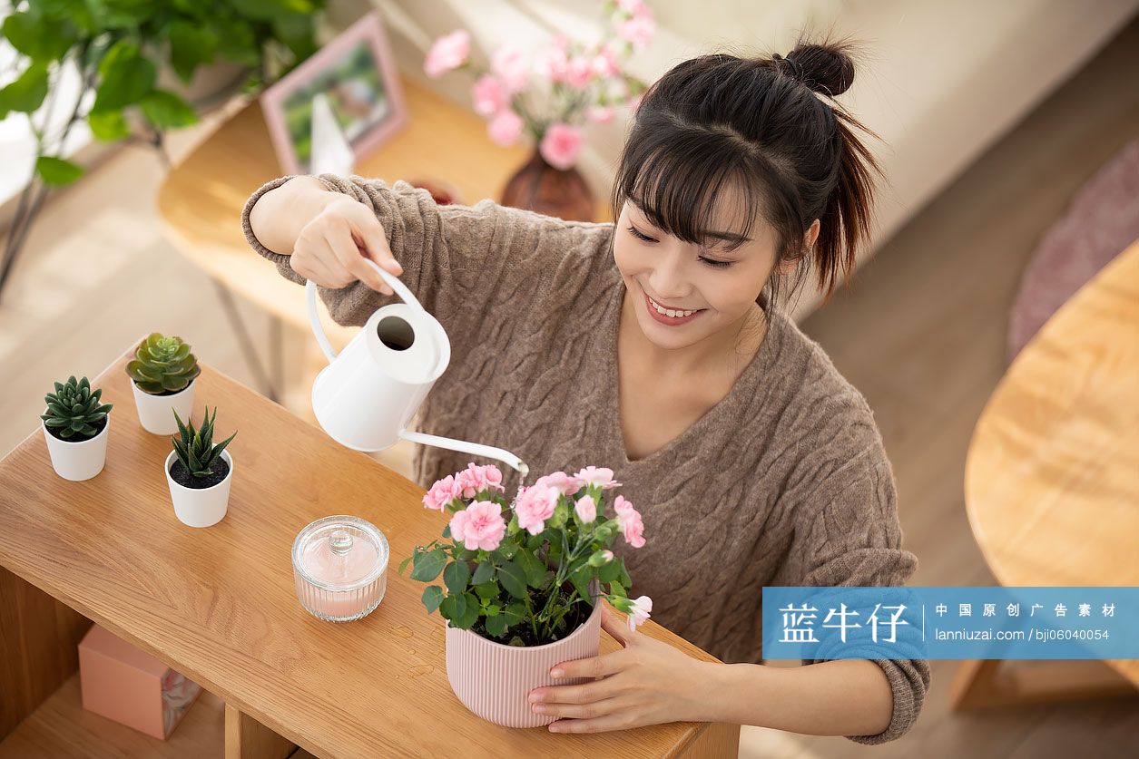 年轻女士在家浇花