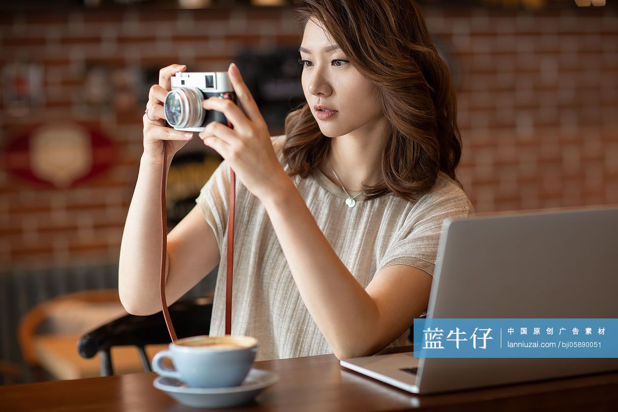 优雅女士在咖啡店使用相机