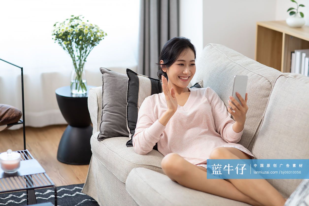 快乐年轻女士在家使用手机视频通话