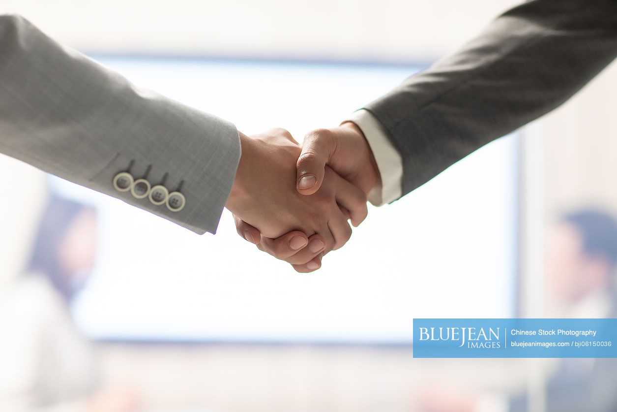 Chinese businessmen shaking hands in office