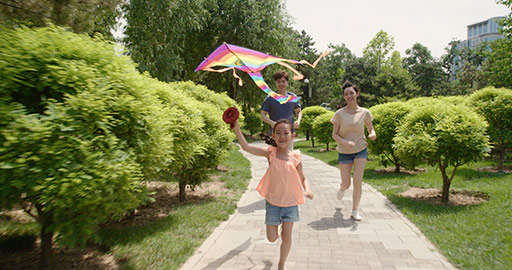 快乐的年轻家庭在公园放风筝