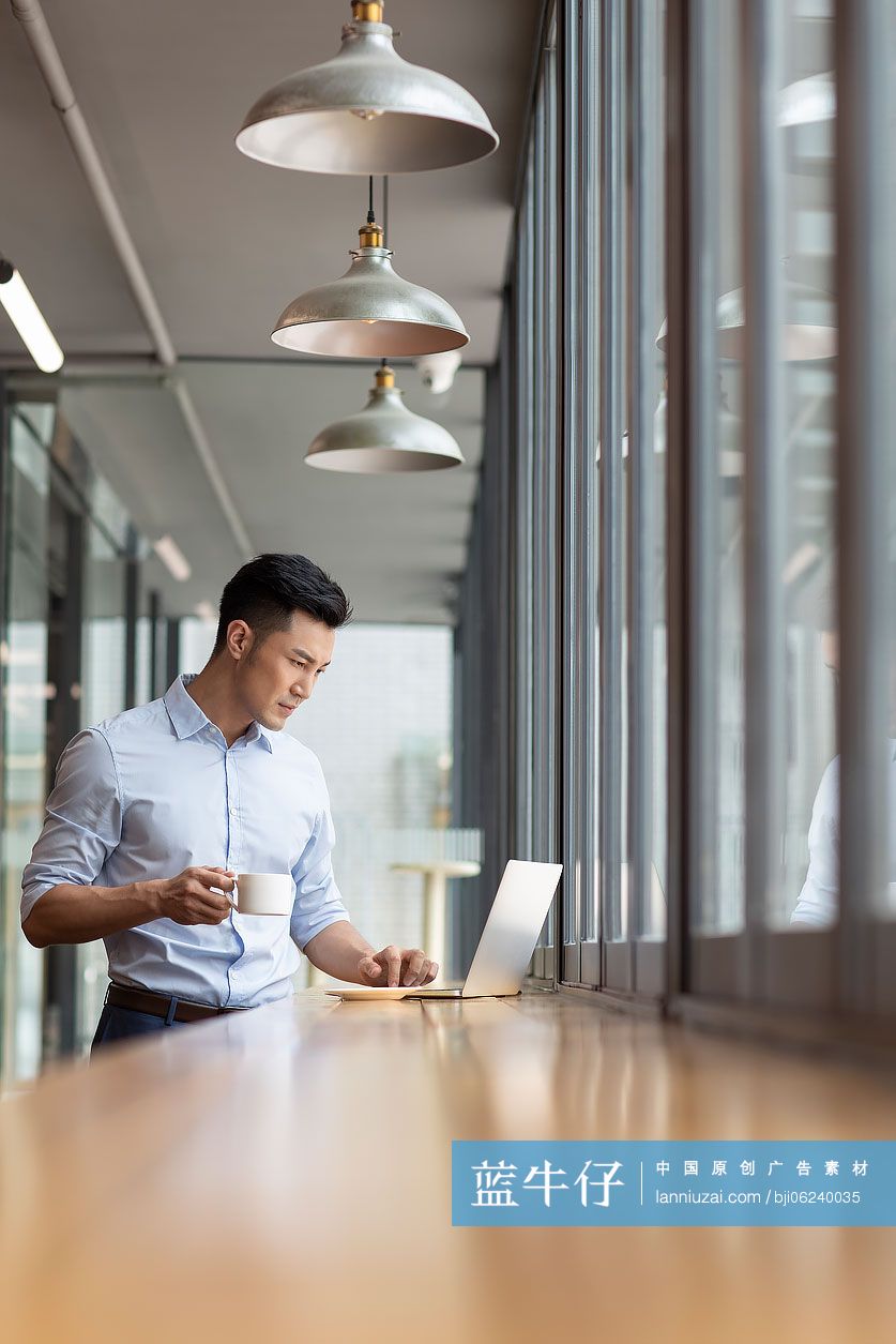 商务男子在咖啡馆使用笔记本电脑工作