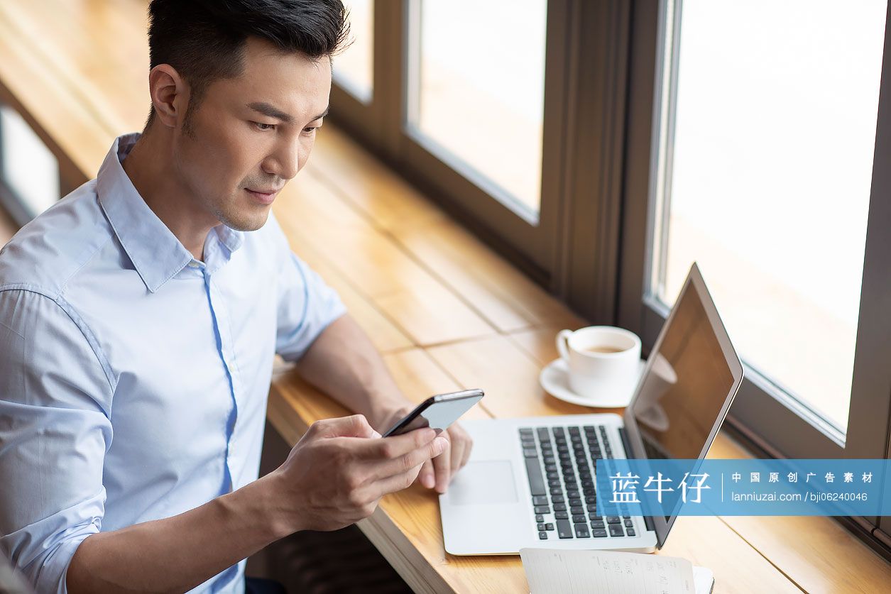 商务男子在咖啡馆使用手机