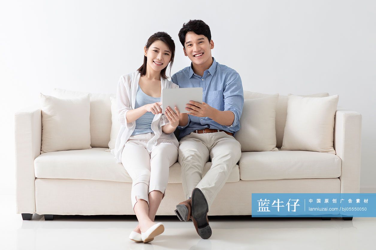 开心的年轻情侣玩平板电脑-蓝牛仔影像-中国原创广告影像素材