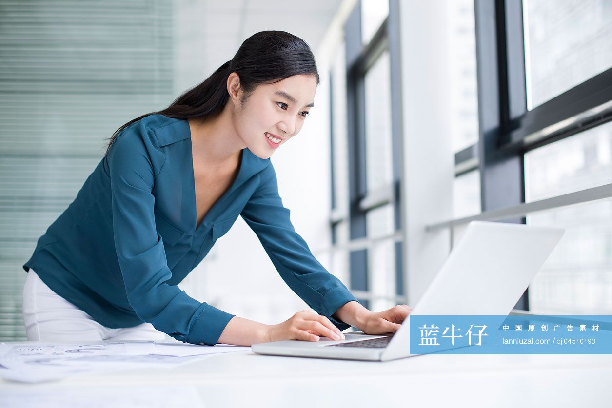 年轻商务女士在办公室使用笔记本电脑