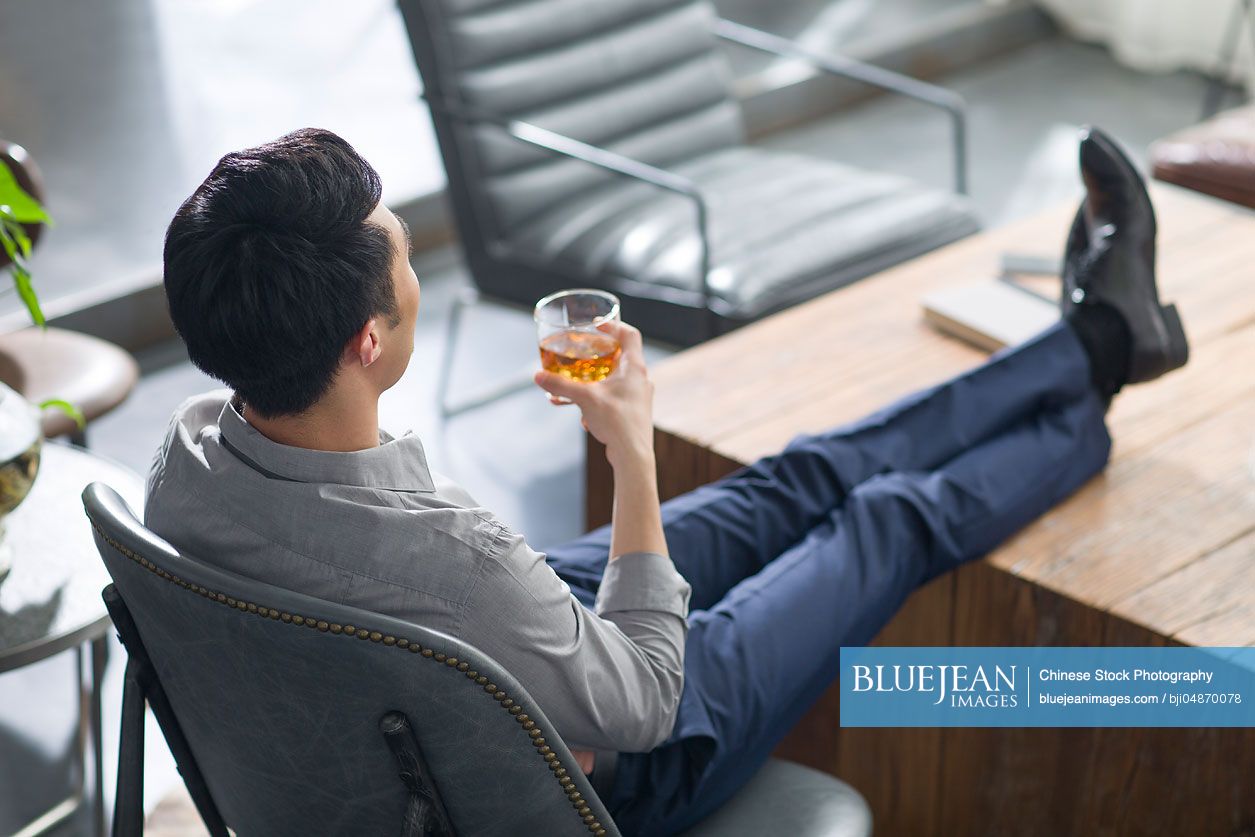 Young Chinese man enjoying fine wine