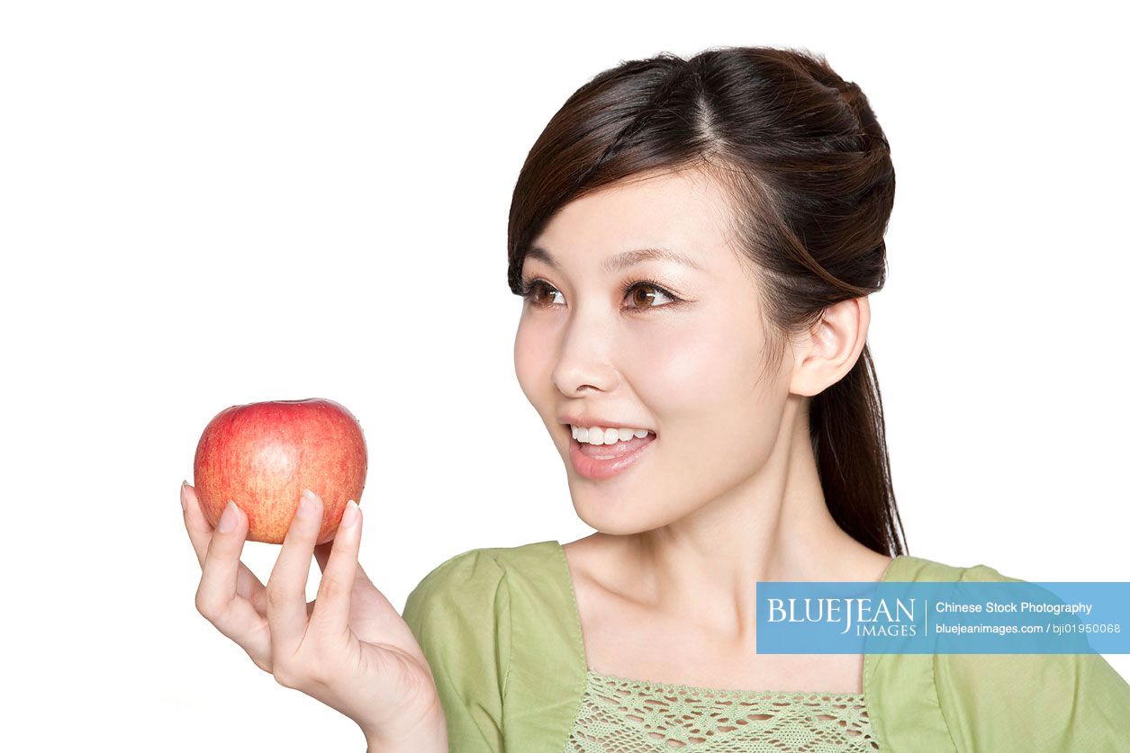 Portrait of young Chinese woman with red apple