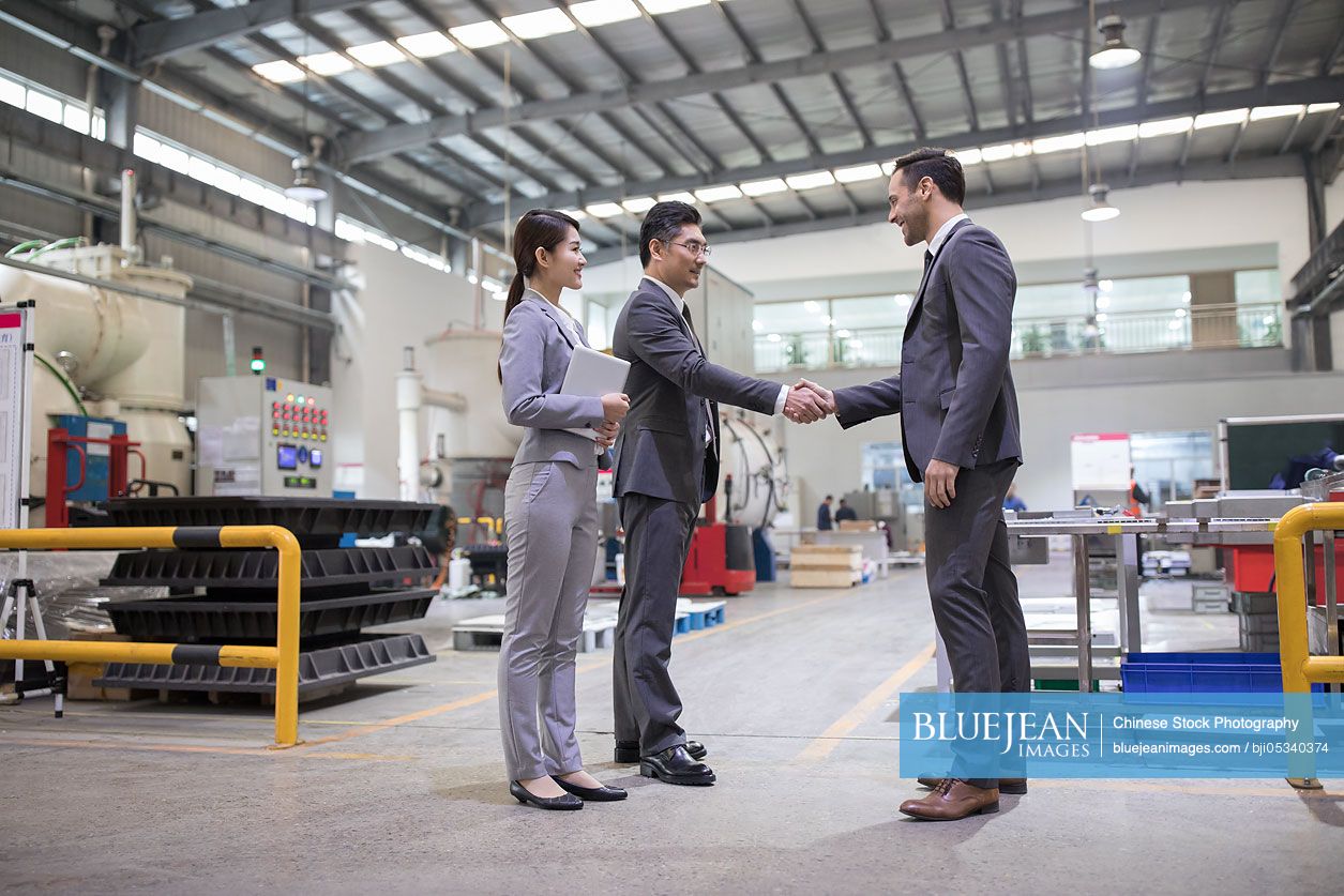 Business people shaking hands in the factory