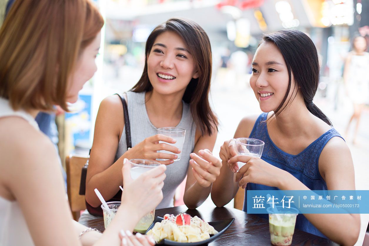 年轻闺蜜在露天咖啡馆聊天