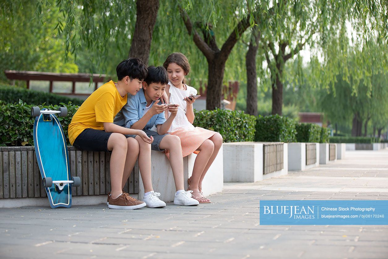 Teenagers using smartphone outdoors