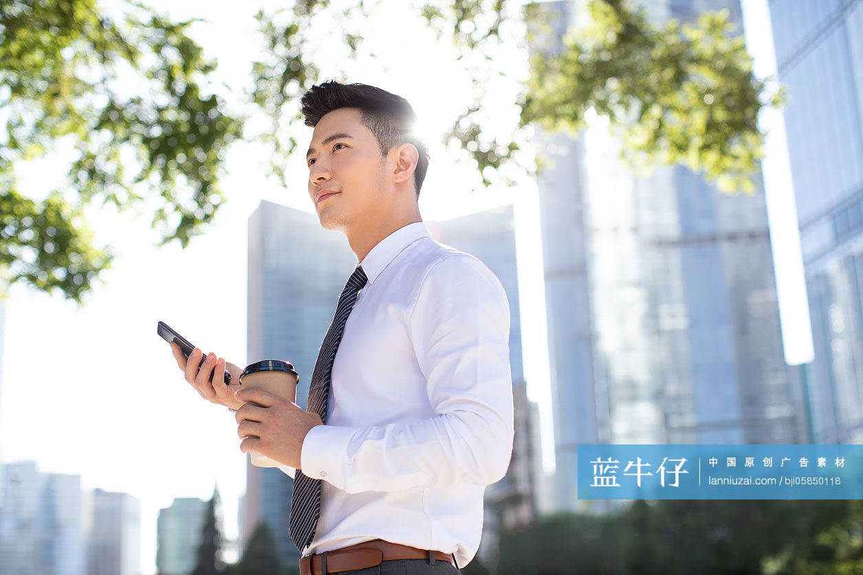 自信的年轻商务男士使用手机