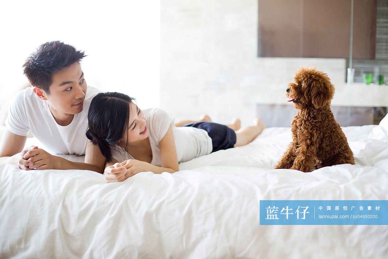 年轻夫妇和宠物狗在家嬉戏