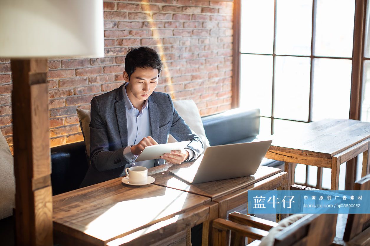 年轻商务男士在咖啡店使用平板电脑