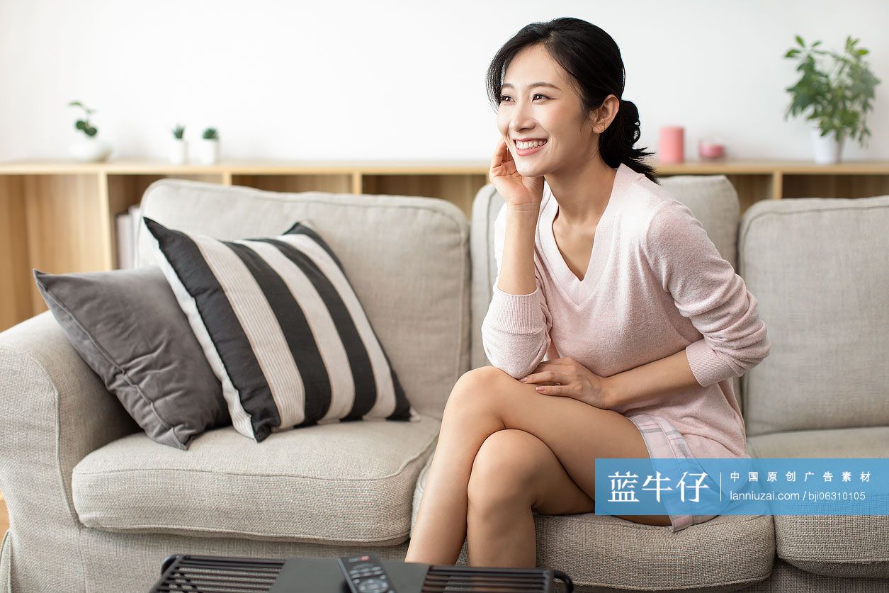 快乐年轻女士坐在沙发上