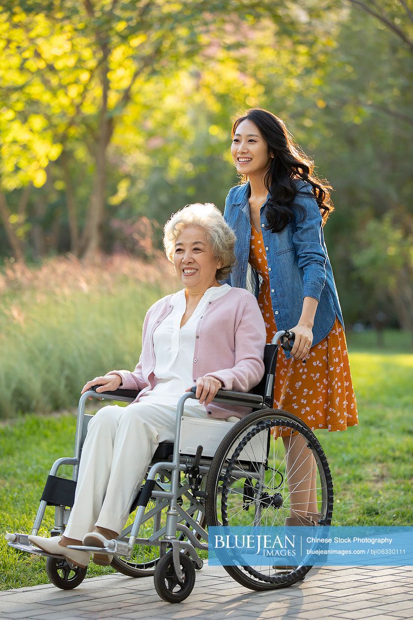 Happy Chinese mother and daughter relaxing in park