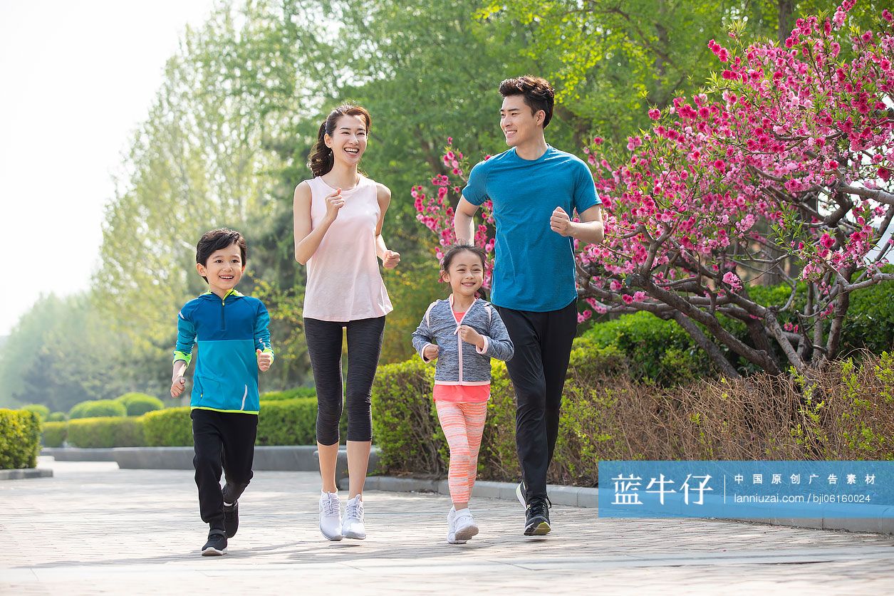 快乐的年轻家庭在公园跑步