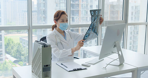 Young Chinese doctor examining X-ray image in office,4K