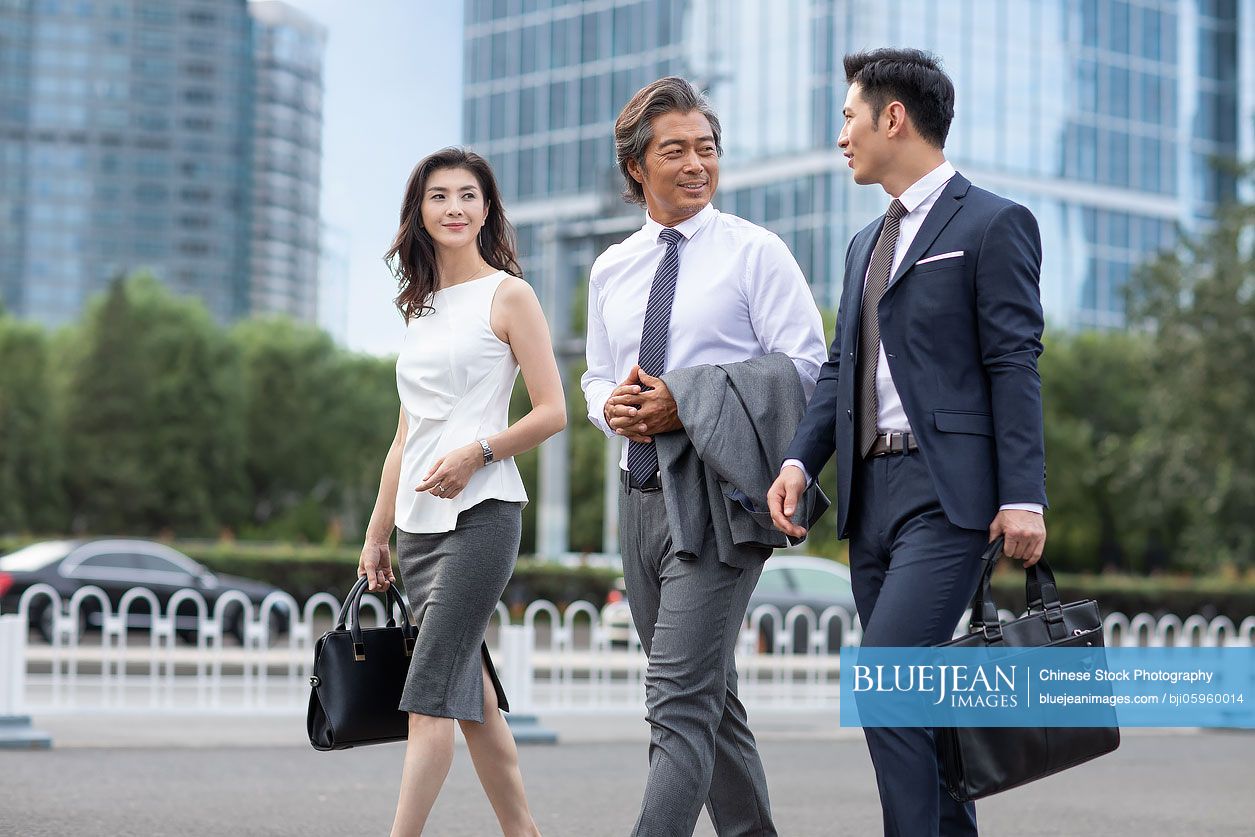 Successful Chinese business people walking on street
