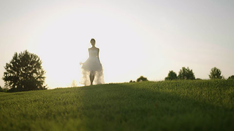 美丽的新娘在草地上奔跑