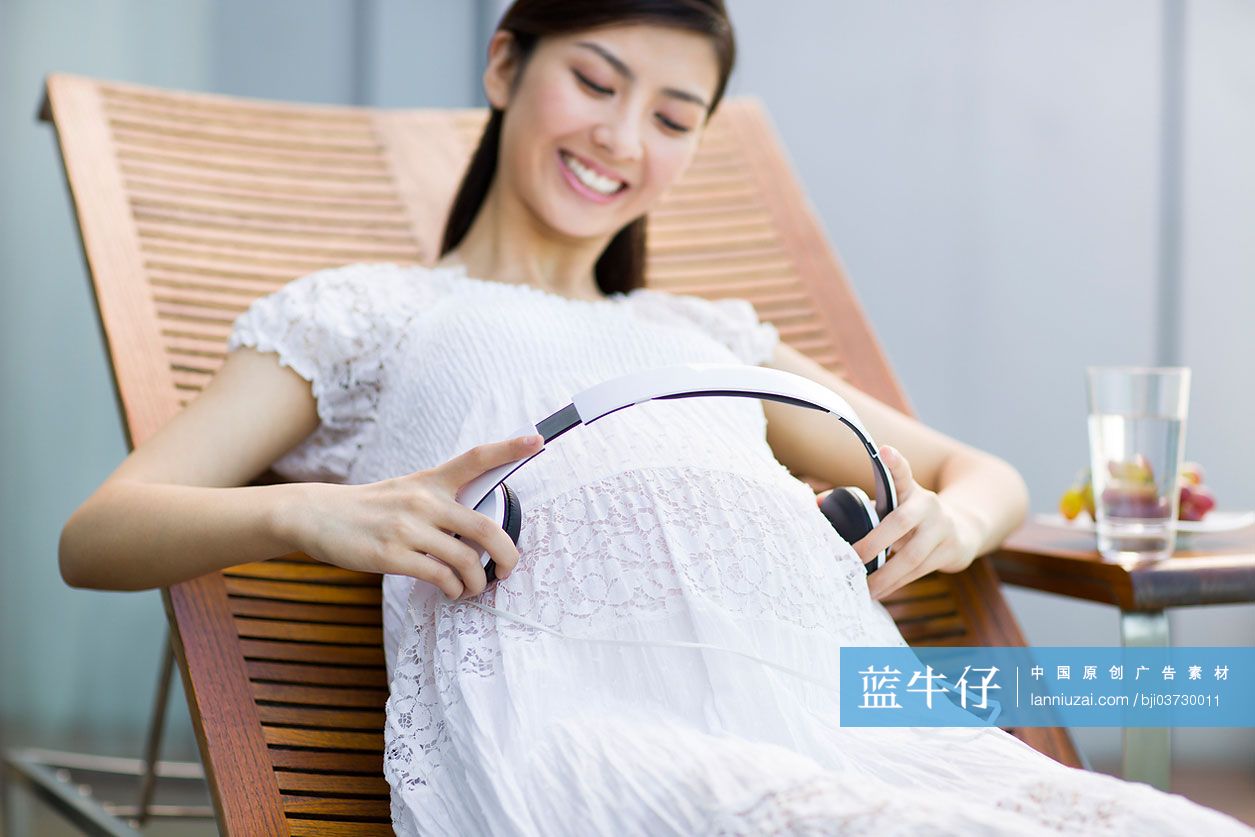 孕妇把耳机放在肚子上