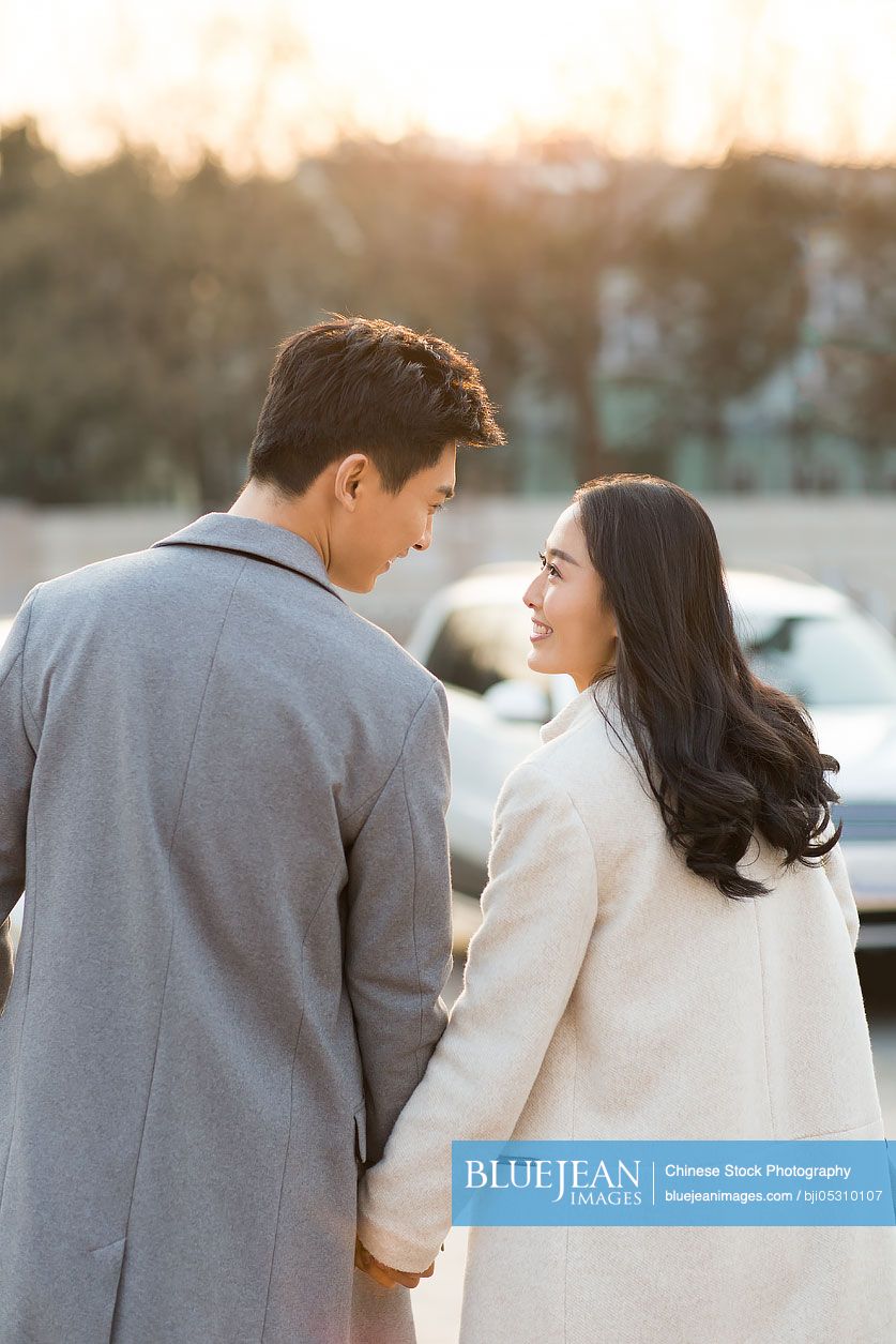 Cheerful young Chinese couple holding hands