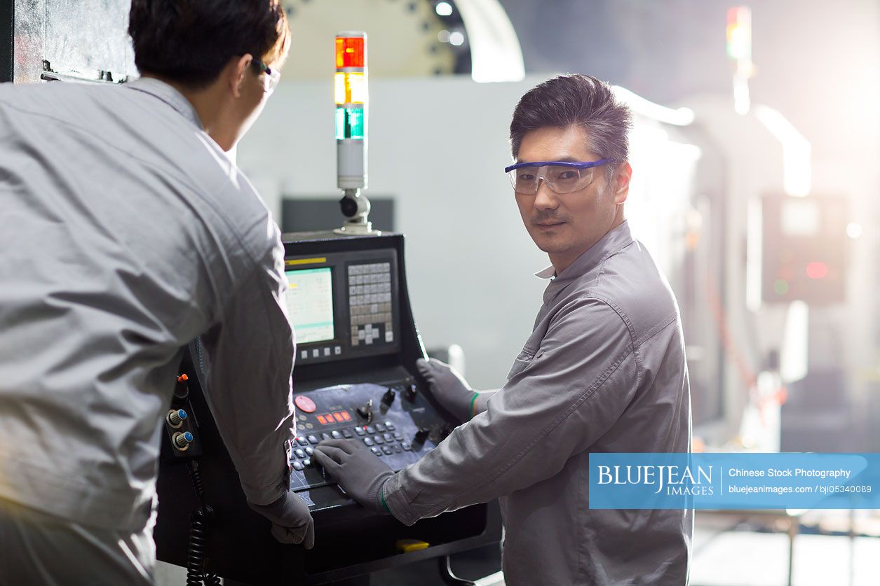 Confident Chinese engineers working in the factory