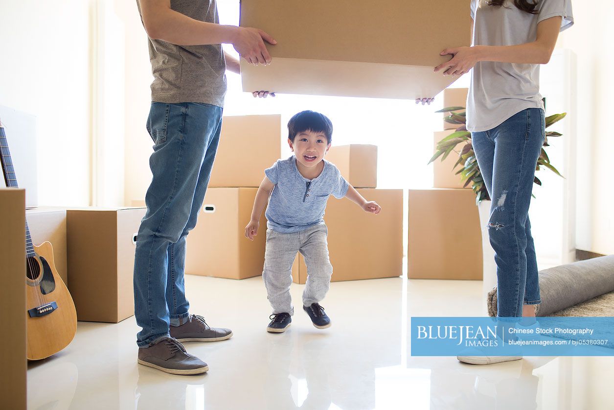 Happy young Chinese family moving to a new house