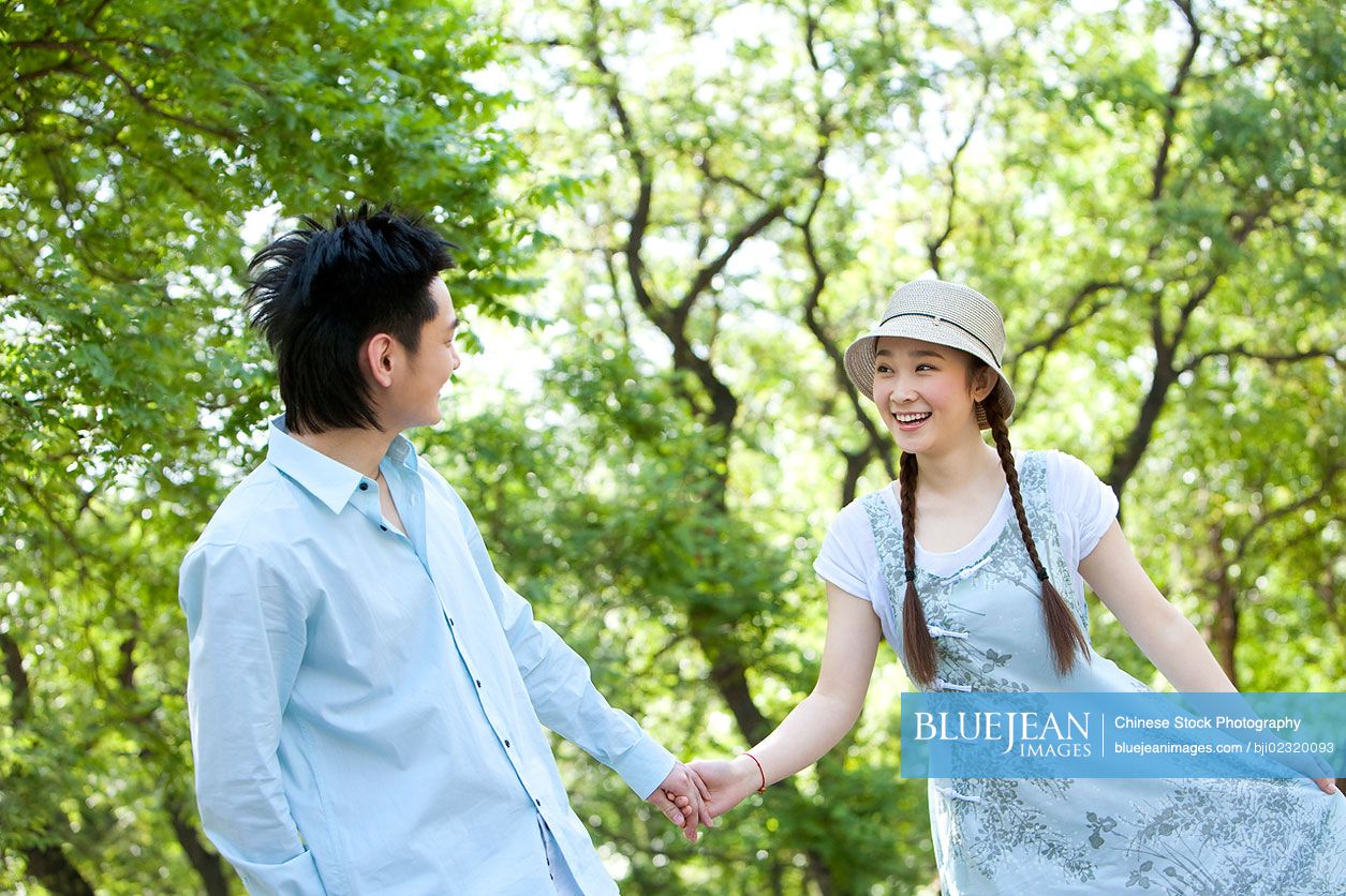 Happy Chinese couple walking through the park