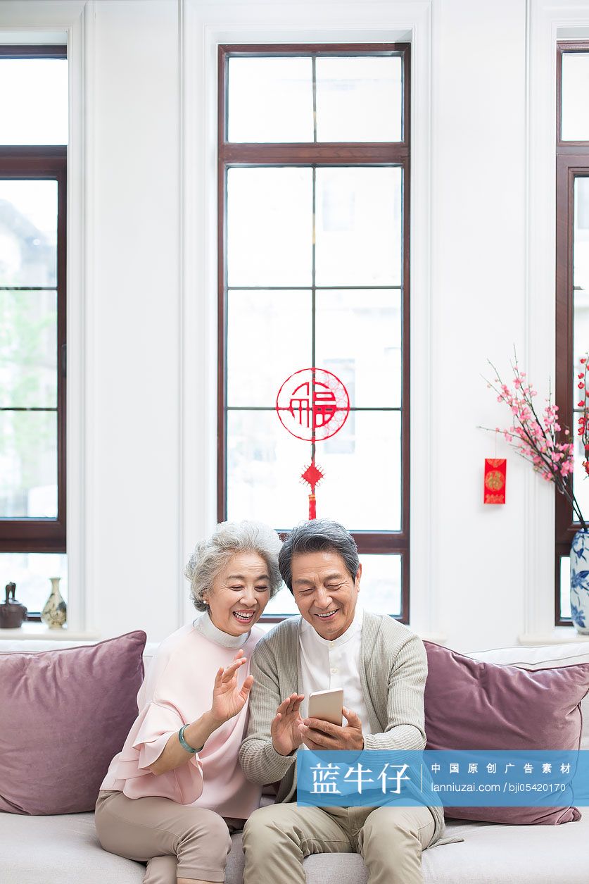 快乐老年夫妇新年用手机视频聊天-蓝牛仔影像-中国原创广告影像素材