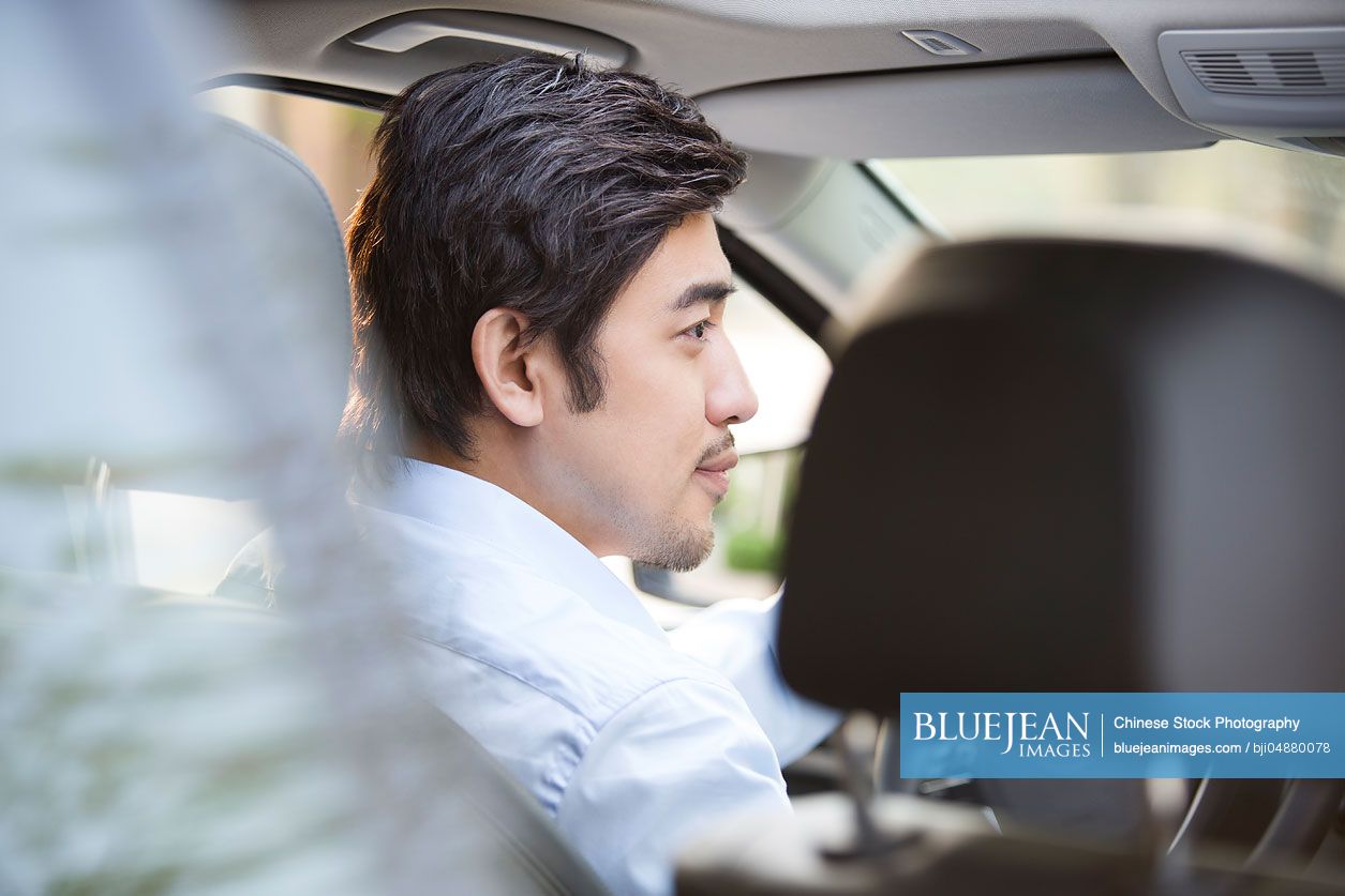 Young Chinese man driving car