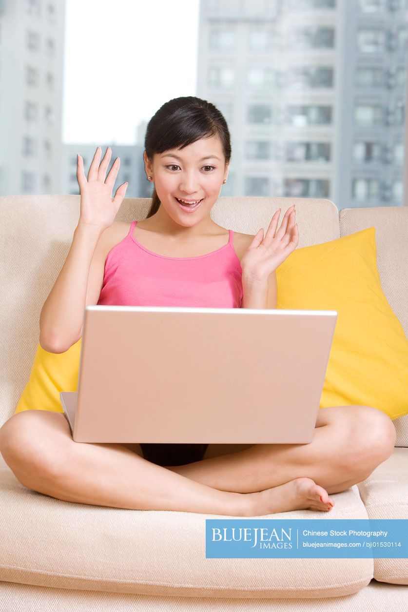 Chinese woman on a sofa with a laptop