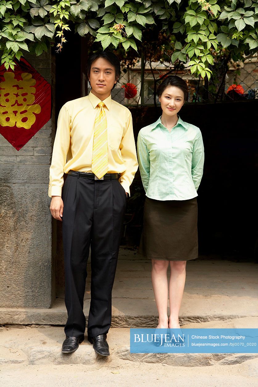 Young Chinese businessman and woman standing outside