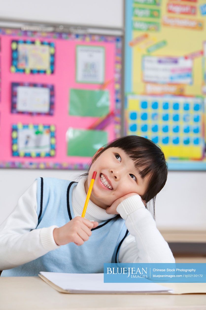 Young Chinese student thinking in classroom