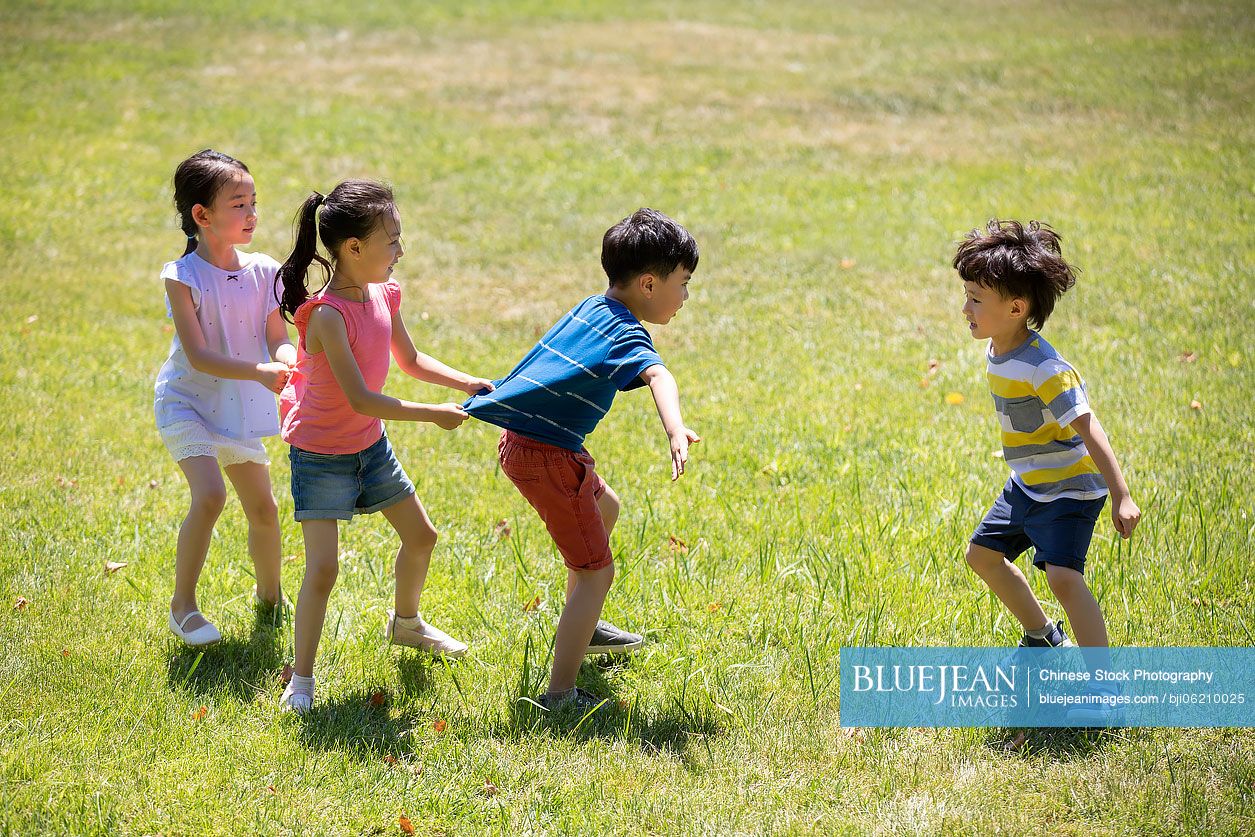 Happy Chinese children playing games on meadow