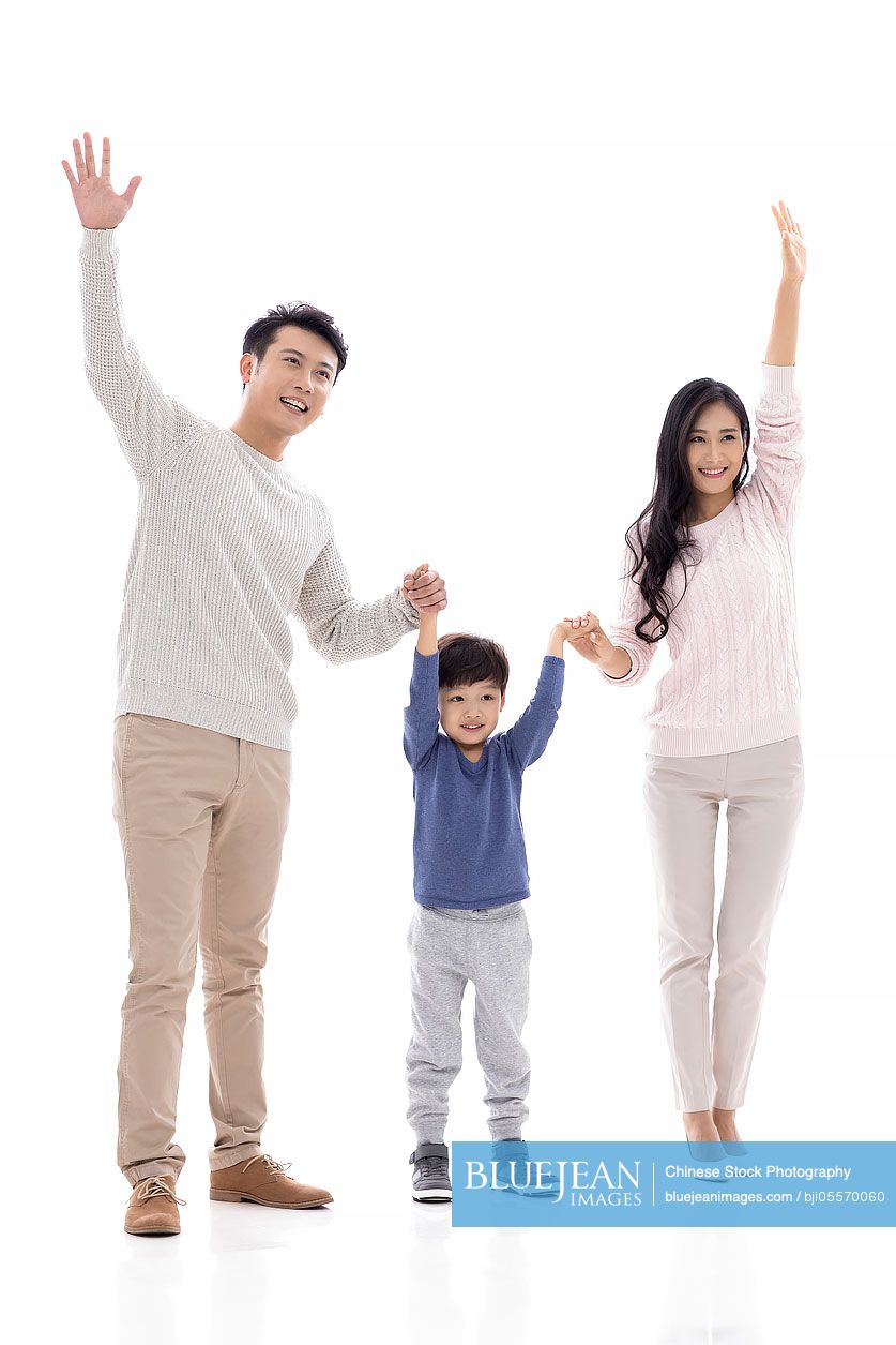Happy young Chinese family waving hands