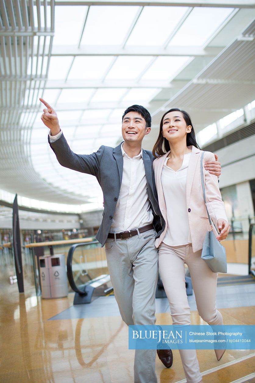 Young Chinese couple walking in shopping mall